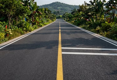 A finished modern asphalt road with clean yellow and white markings through a lush landscape, showcasing infrastructure excellence, high-resolution photography, morning light.