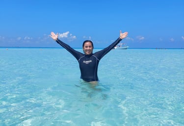 Playa azul turquesa, con un cielo azul despejado y una persona en el agua