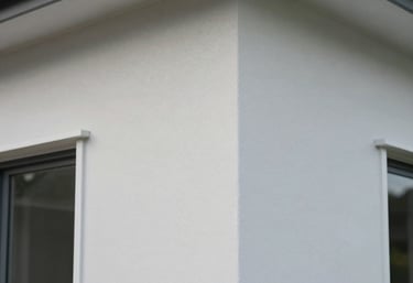 A detailed photography shot of a perfectly finished exterior corner of a modern house in New Zealand, showcasing the smooth paint texture and clean lines.