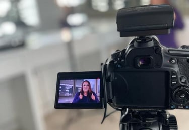 Cámara DSLR profesional sobre un trípode grabando a una presentadora durante una producción