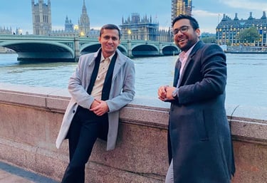 two men standing next to each other on a bridge