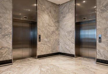 A wide shot of a modern building lobby with marble floors and silver elevator banks in a South American / Colombian city, high-end professional look.