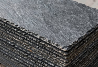 A stack of high-quality dark grey slate tiles ready for installation, clean composition, natural outdoor lighting, reflecting industrial durability.