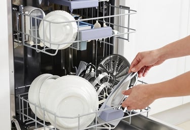 Technician repairing a modern refrigerator in a bright kitchen.