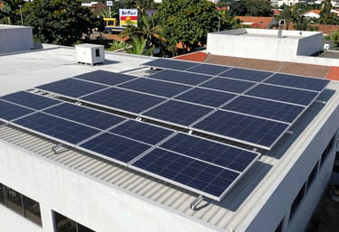 Technician inspecting solar panels on a commercial building rooftop in Tupandi.