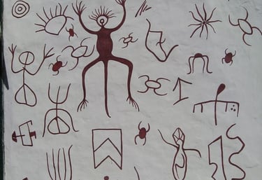Art petroglyphs and tribal symbols depicting human figures and animals on a white wall of Guane