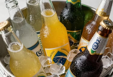 A vibrant collection of various cold beverage bottles in an ice bucket, with condensation and bright lighting, reflecting a refreshing Brazilian mood.