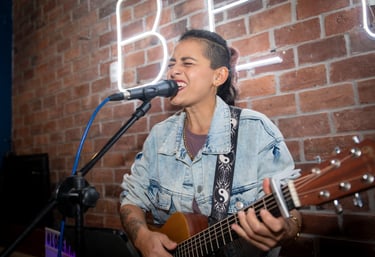 Lorena Uría cantando en formato solista, voz y guitarra, en un bar de Miraflores, Lima, Perú.