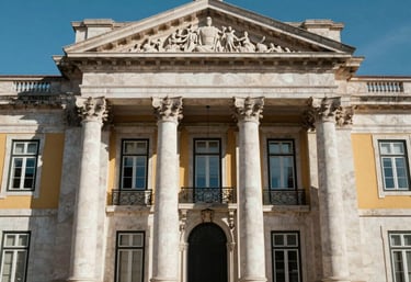 The facade of a historic legal building in Lisbon with classical columns and a clear blue sky, capturing the prestige and history of the law.