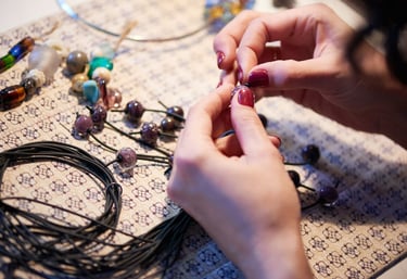 Creador de joyería artesanal enseñando a crear piezas de macramé y piedras preciosas.