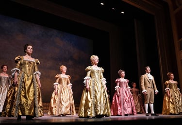 A low-angle shot of a grand opera stage during a performance, intricate period costumes in gold and deep rose, dramatic stage lighting, professional theatrical composition.