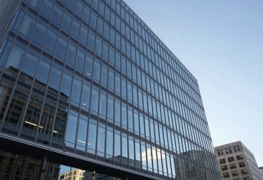 Professional exterior photography of a modern glass corporate headquarters in a North American business district under a clear sky.