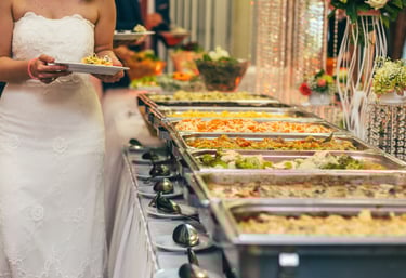 Catering a wedding reception with a woman wearing white and a line of food