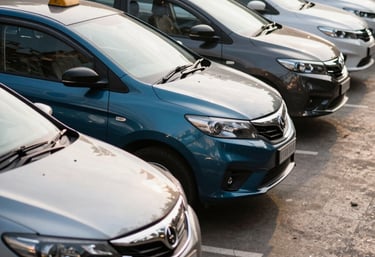 A fleet of professionally branded cabs lined up in an urban South Asian plaza, sleek modern photography style, daylight, steel blue and charcoal tones.