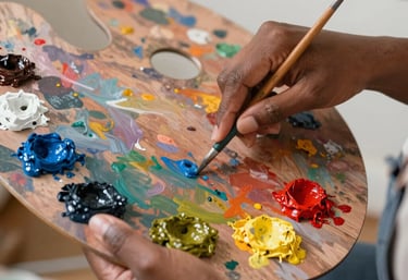 Close-up of a colorful canvas mid-paint, with brushes and palette nearby.
