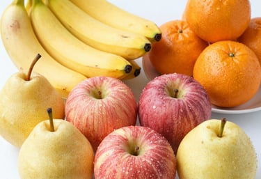 A colorful basket overflowing with ripe apples, oranges, and bananas on a rustic wooden table.