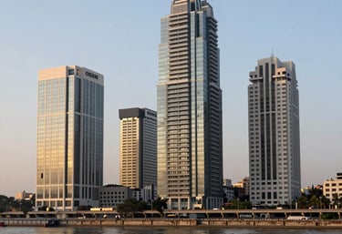An architectural shot of Ahmedabad's modern commercial district with the Sabarmati Riverfront visible, clean lines, professional atmosphere, golden hour lighting.