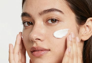 Close-up of a woman gently touching her clear, radiant cheek, smiling softly.