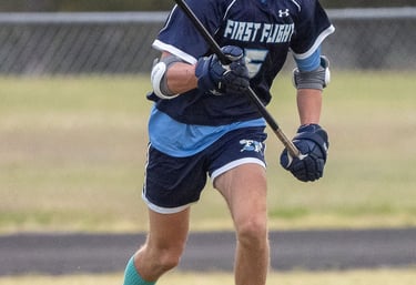 First Flight lacrosse player, Cam Van Lunen, playing defense.