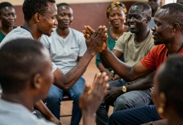 A diverse group of Kenyan community members gathered outdoors, sharing stories and support.
