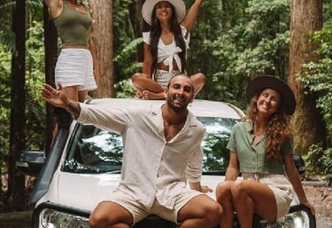 A group of friends on a tropical 4x4 road trip adventure in a lush green rainforest.