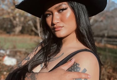 Amelia posing outside in a black cowboy hat