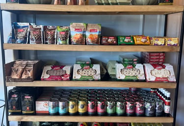 Wooden grocery shelves stocked with Turkish tea, delight, helva, and spices for sale.