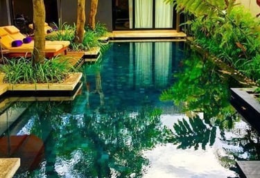Balinese-style pool with deep green water and dark emerald mosaic tiles for a jungle-inspired finish
