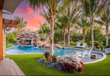 Tropical freeform pool with aqua water, rock grotto and light blue tiling for a vibrant lagoon look.