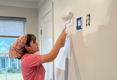 Team member painting a customer's wall white.