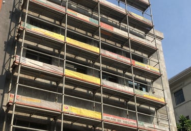 Modern office building under construction with clear blue sky background.