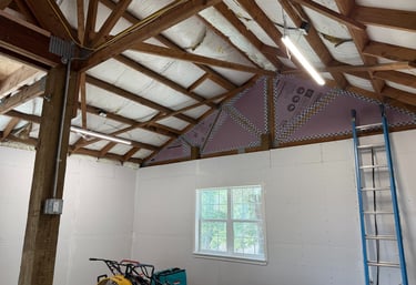 shop lighting interior under construction with drywall installation, pink rigid foam insulation
