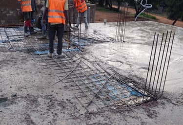 a group of men in safety vests working on a concrete slab