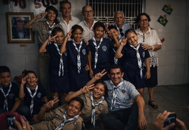 A group of Brazilian scouts in blue uniforms posing for a group photo with leaders and elders.