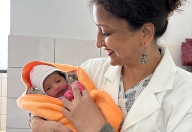 Dr. Renu Agrawal Rini Hospital Dholpur, a woman in a white coat holding a baby in a Hospital