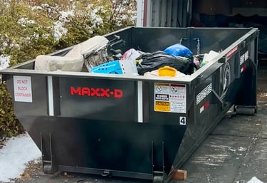 A black dumpster filled with junk