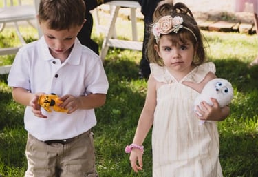 A young flower girl and ring bearer playing on the grass at an outdoor summer wedding. Athens, Oh