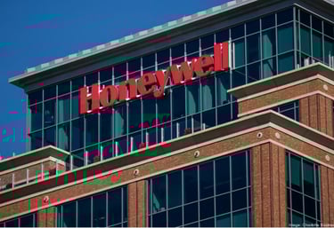 Siège de l'entreprise Honeywell avec logo rouge sur un bâtiment moderne en verre et briques rouges