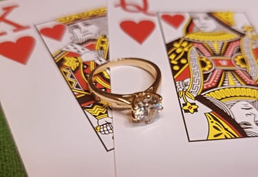 an engagement ring atop of the king and queen of hearts