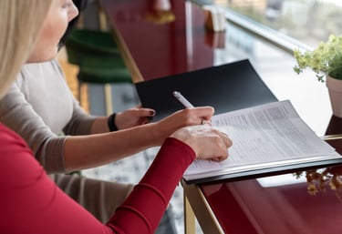 Deux personnes travaillant ensemble sur un document, l'une prenant des notes.