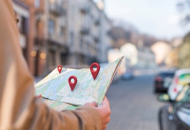 Personne tenant une carte avec des repères de localisation.