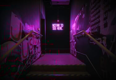 A hallway with a neon sign at the end