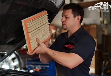 Fast Tire Shop mechanic replacing air and oil filters during fluid maintenance service