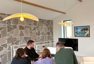 A diverse team collaborating in a modern office with stone walls and stylish pendant lighting.