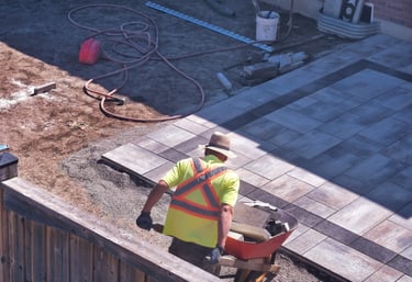 Sarasota patio installation in progress with contractor laying multicolor concrete pavers and gravel