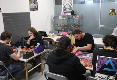 People playing card games inside the Crow's Nest TCG shop.