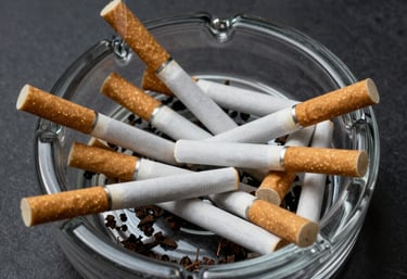 A hopeful person breaking a cigarette in half outdoors at sunrise.