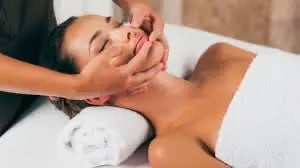 a woman getting a facial massage at a spa