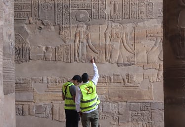 X-Dimension in safety vests examine ancient Egyptian hieroglyphics and stone carvings at the Temple.