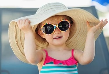 criança com chapéu de praia